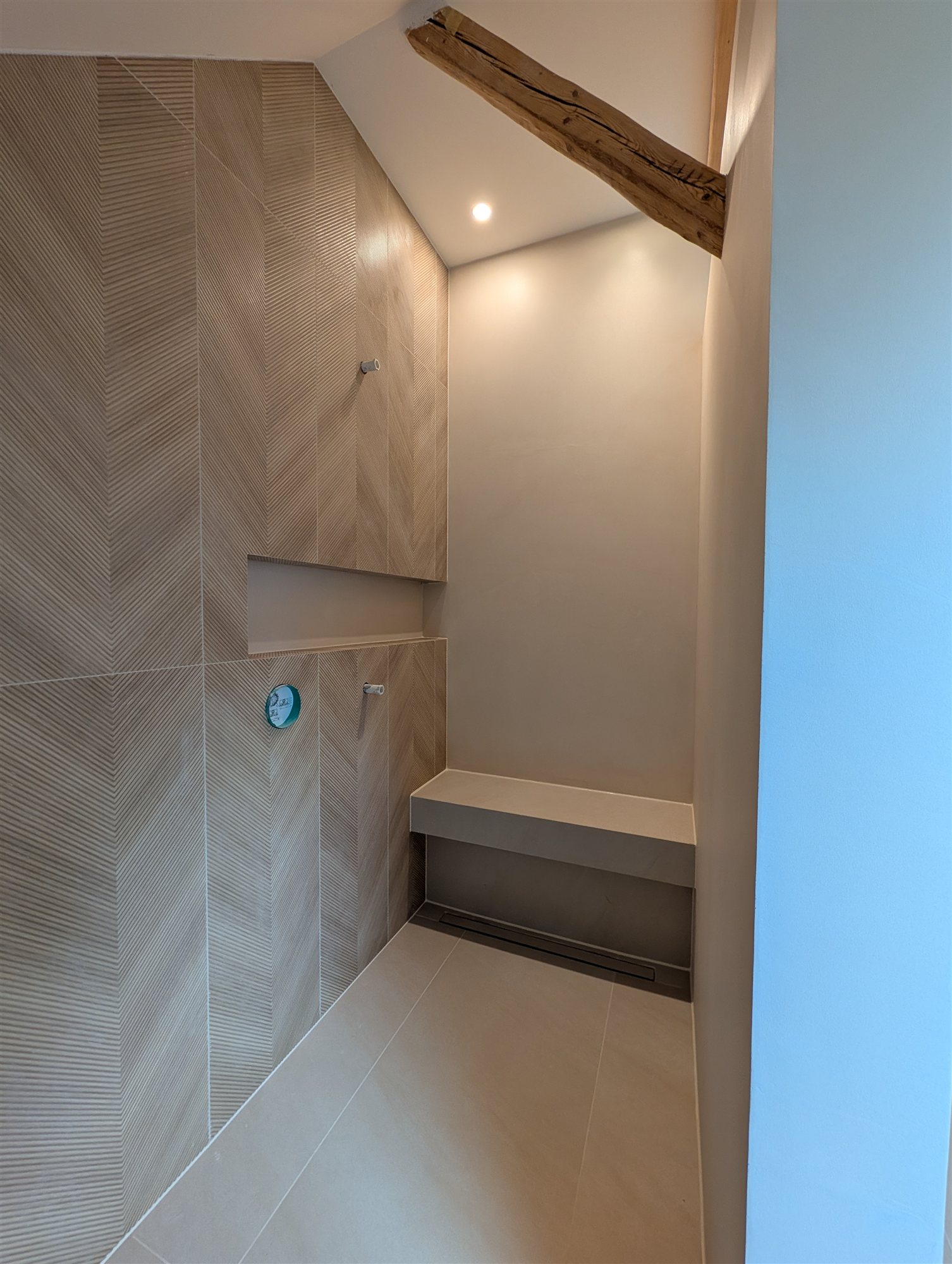 Dusche in Steinbrink nach der Sanierung – bodengleich mit Sitzbank und Wandnische